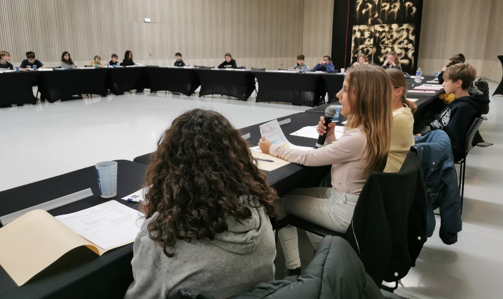 Une jeune fille prenant la parole lors d'une séance plénière du Conseil municipal des jeunes.