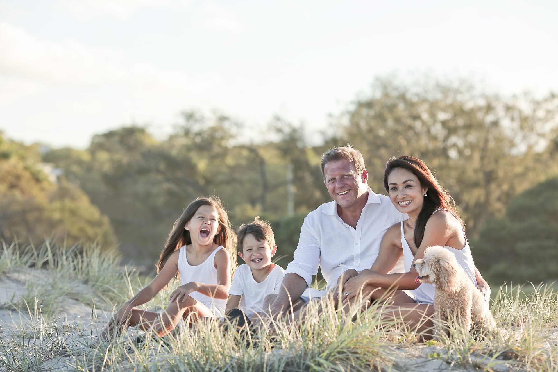 Un père, une mère et leurs deux enfants assis dans l'herbe
