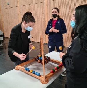 Trois jeunes femmes participent à une animation.