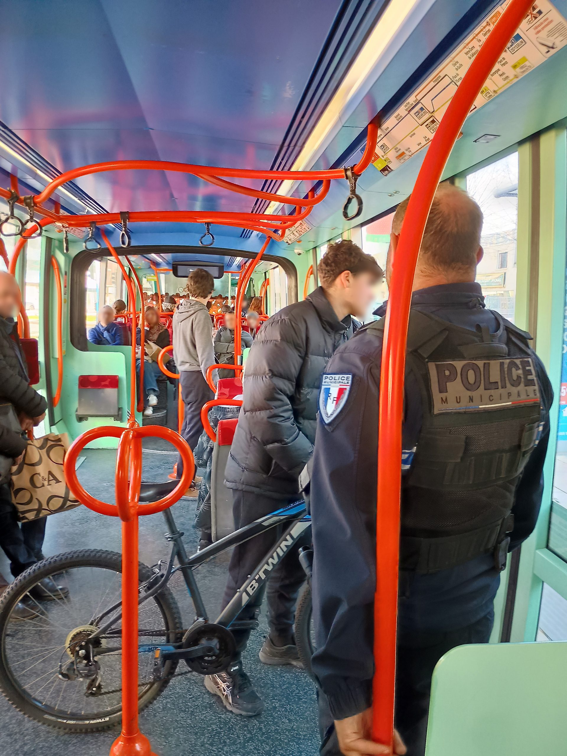 Un policier rappelle à l'ordre une personne qui n'a pas plié son vélo dans le tramway
