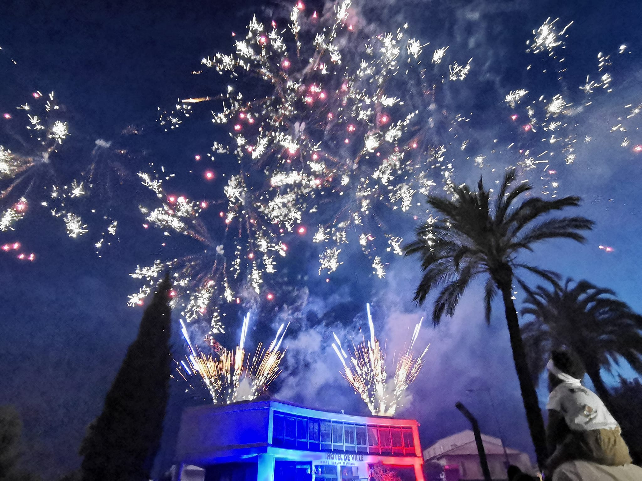 un feu d'artifice tiré sur le toit de l'hôtel de ville de Castelnau-le-Lez en 2024 pour la fête nationale