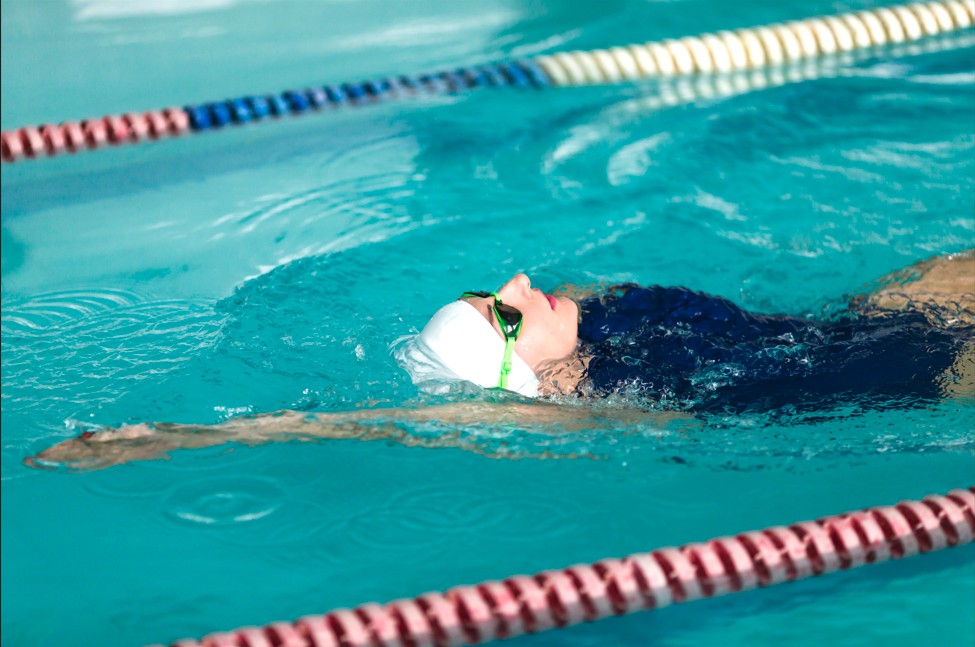 Une nageuse avec bonnet de bain dans un couloir de natation