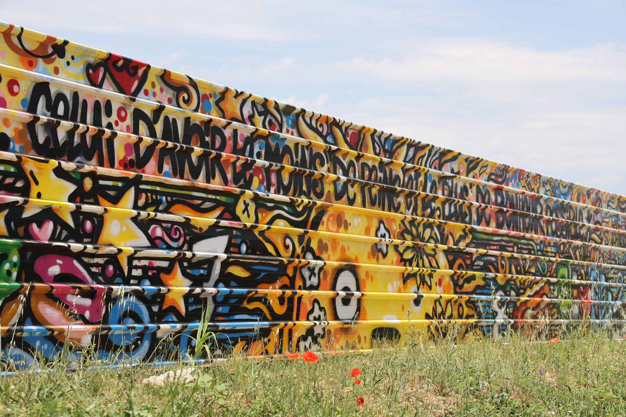 Une fresque de Jaké, de style street art, avec une citation, sur une palissade