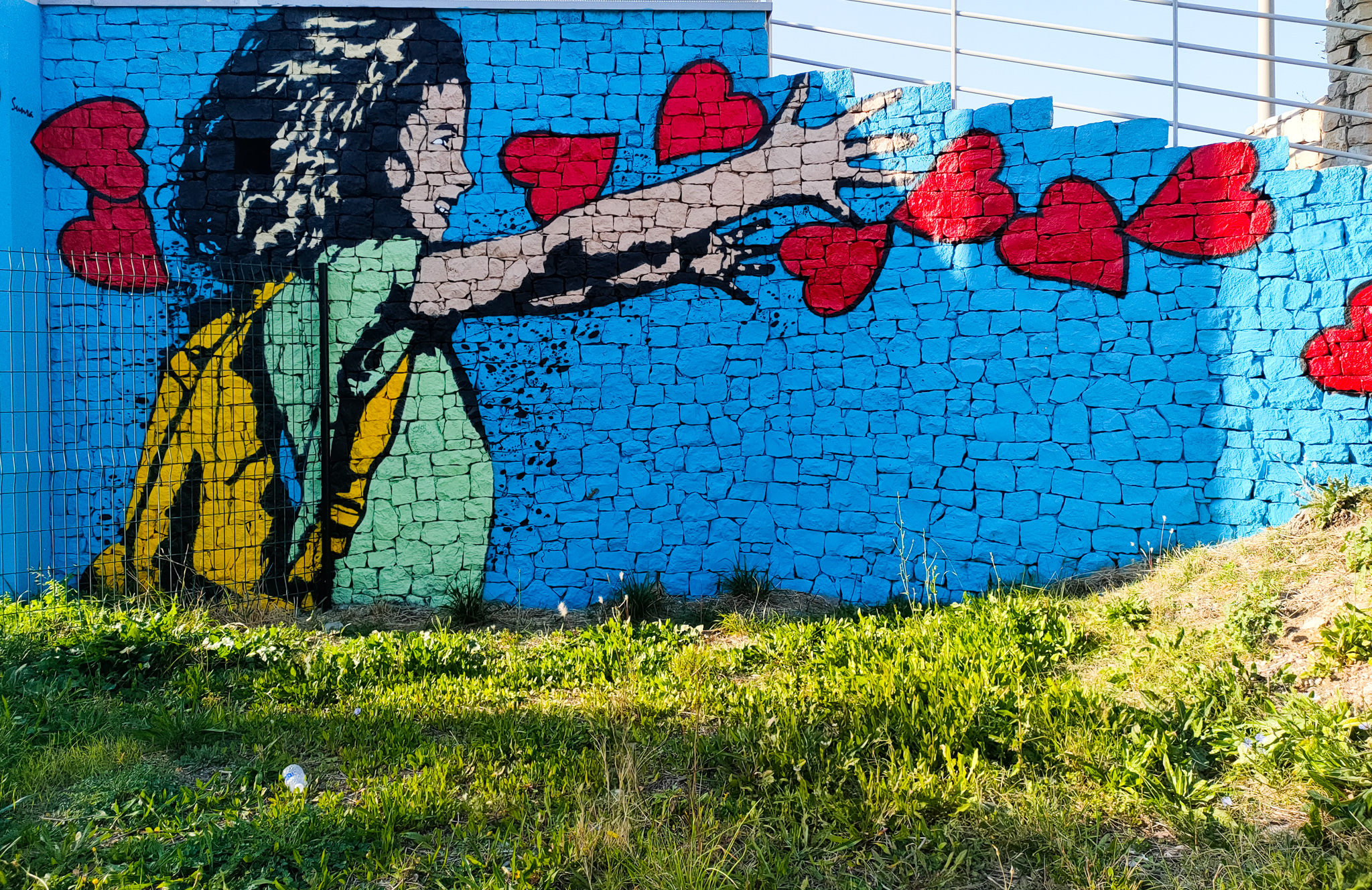 Une fresque de street art représentant une jeune femme lançant des cœurs