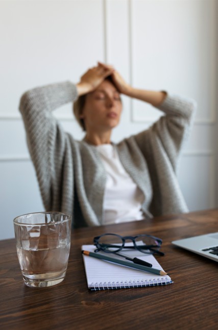 Une femme fatiguée, tenant sa tête entre ses mains