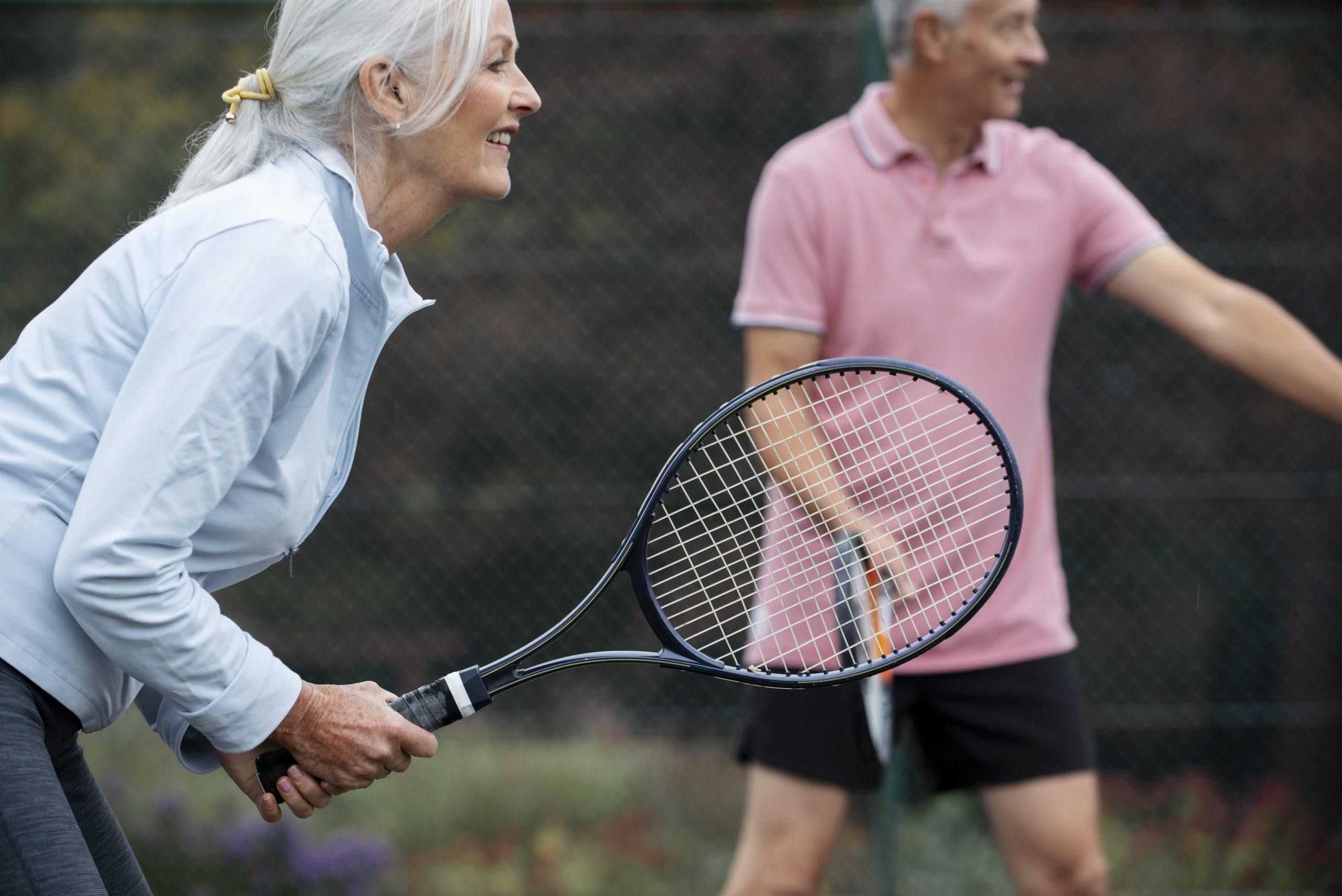 Deux personnes aux cheveux grisonnants qui jouent au tennis