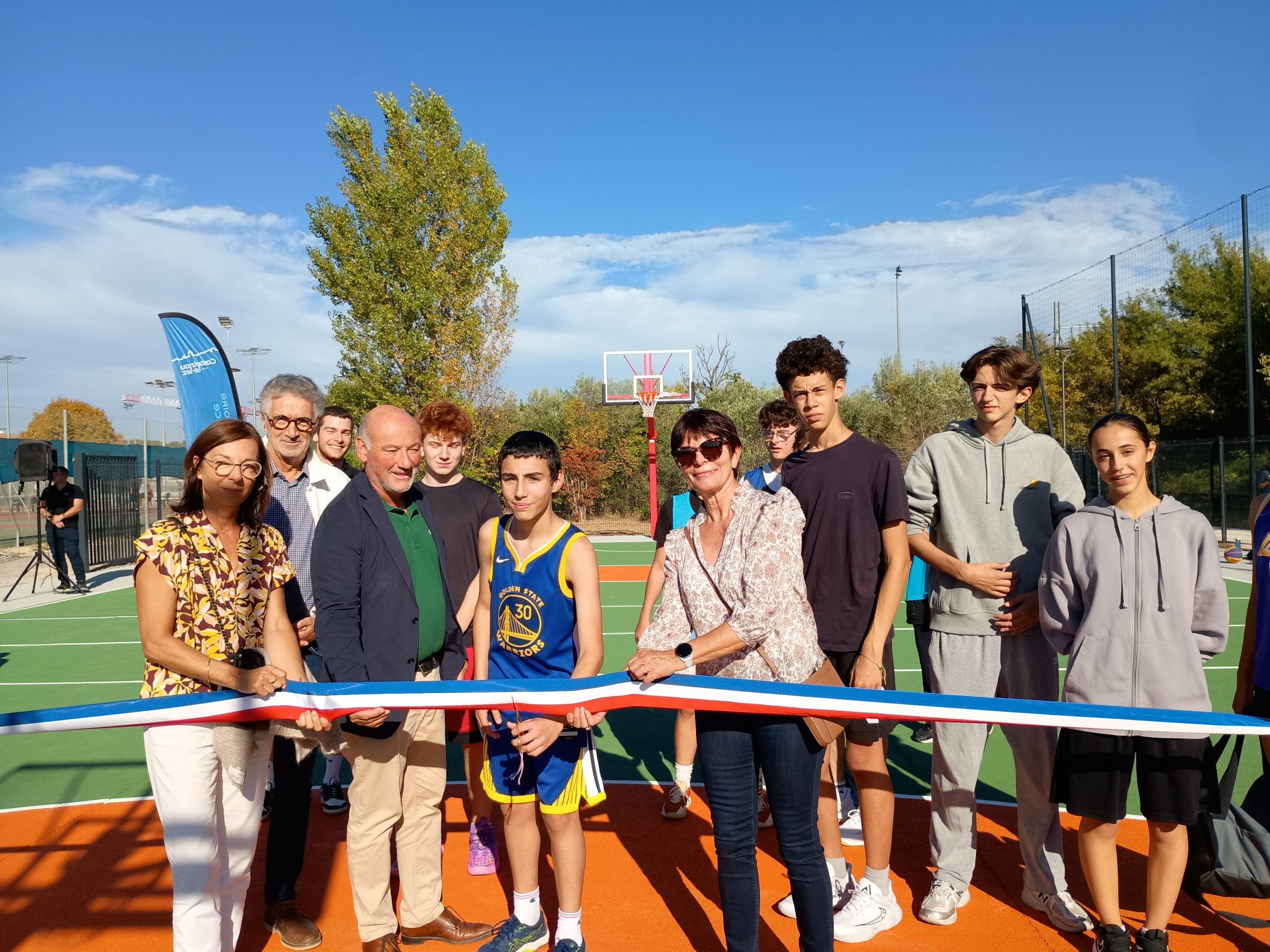 Le Maire et l'adjointe à l'éducation de Castelnau-le-Lez coupent le ruban inaugurant le double terrain de basket 3x3