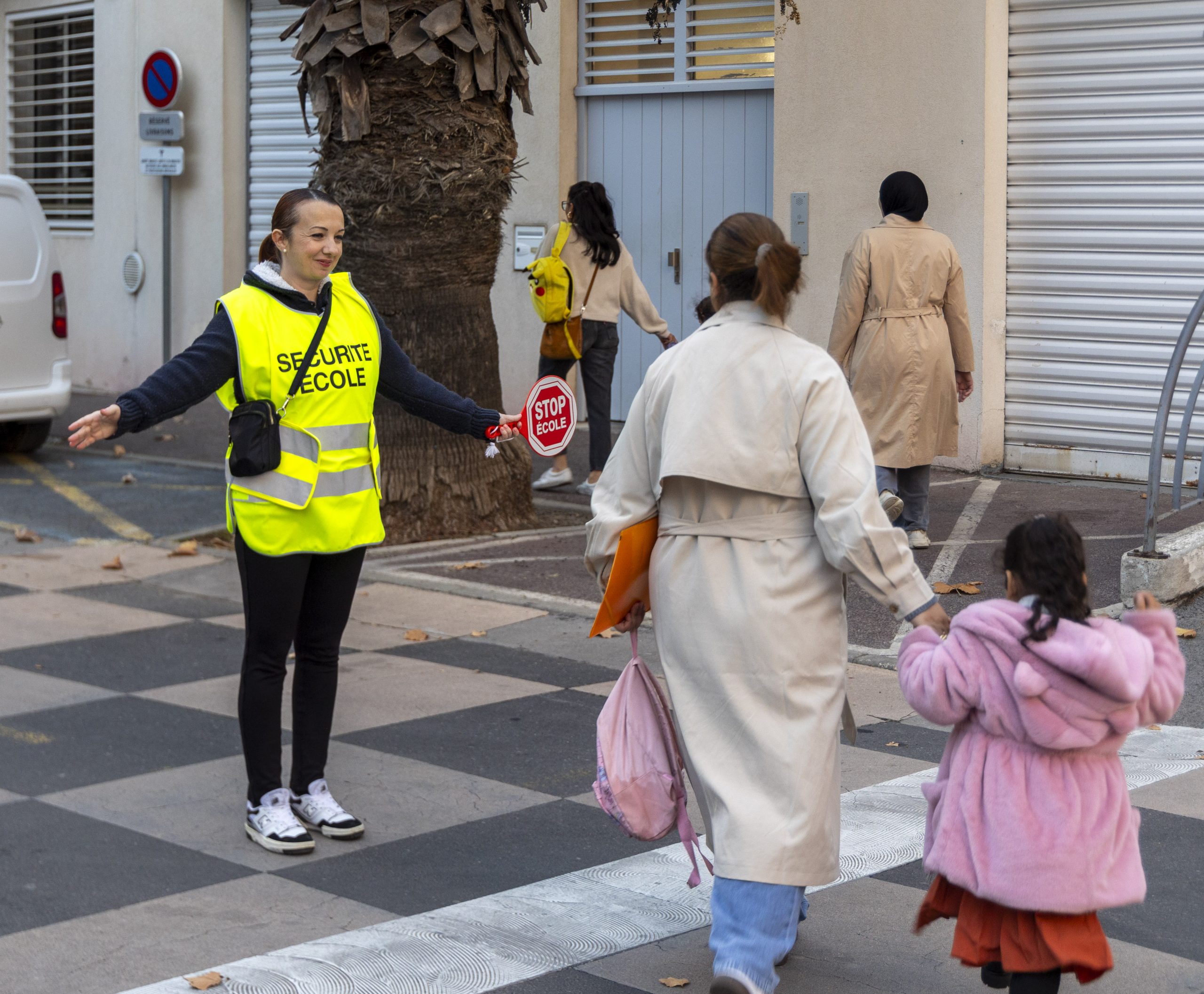 Lydie Becat faisant traverser le passage piétons à des enfants et des adultes
