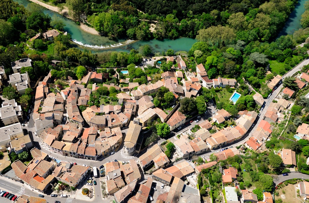 Une vue aérienne de Castelnau-le-Lez entre maisons anciennes, fleuve Lez et grands arbres