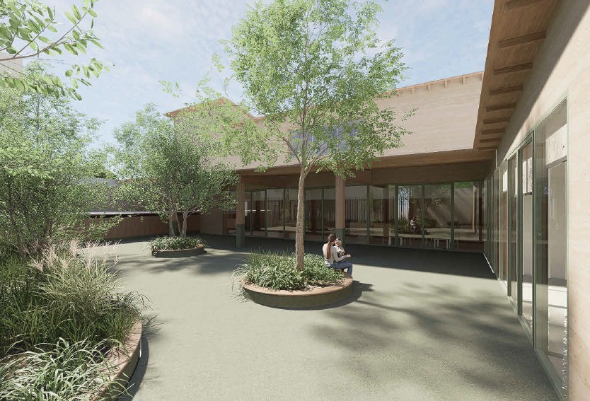 la cour de la crèche La Ruche, à Castelnau-le-Lez, avec un arbre planté sur un îlot central , des bâtiments en arrière-plan