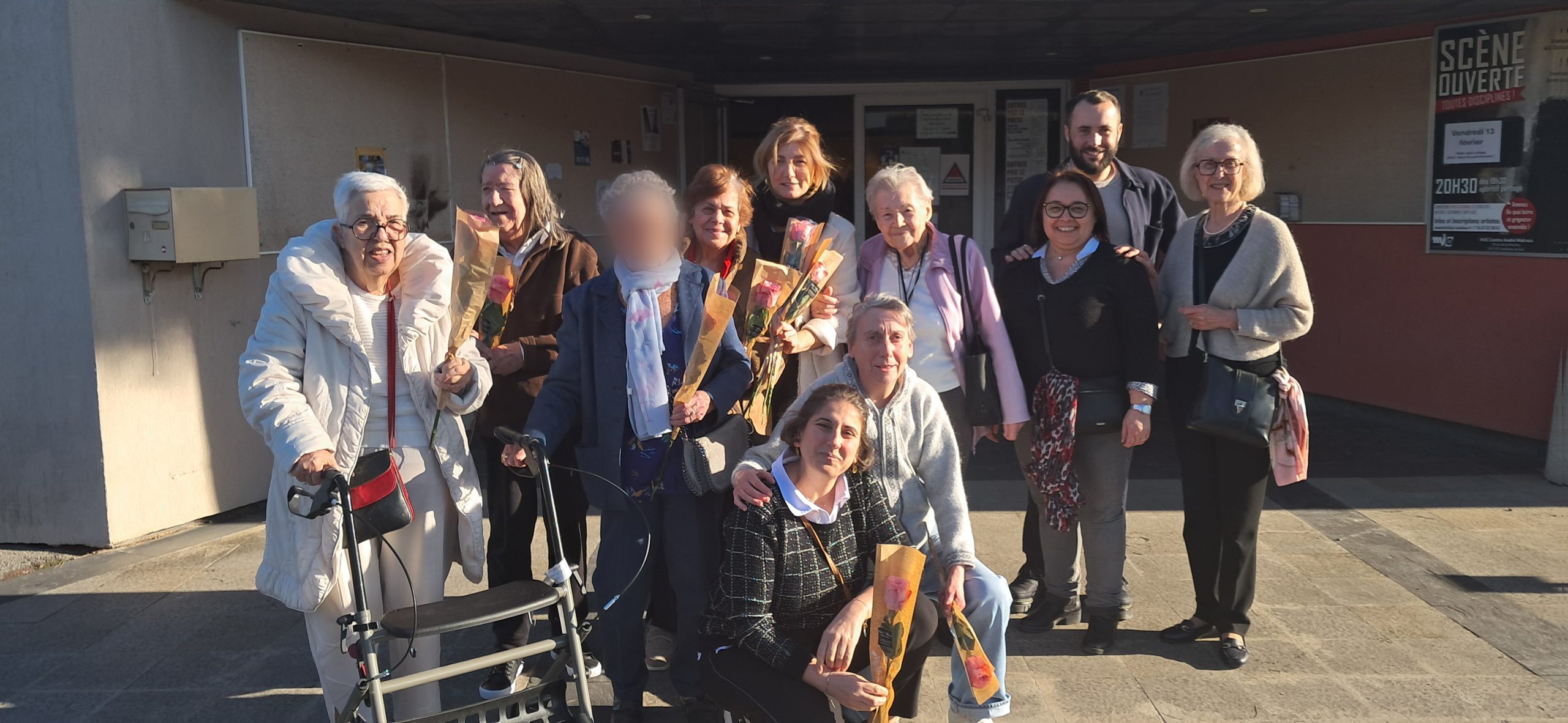 Des femmes âgées, valides ou en fauteuil roulant, une rose à la main, à la sortie de la MJC de Castelnau-le-Lez