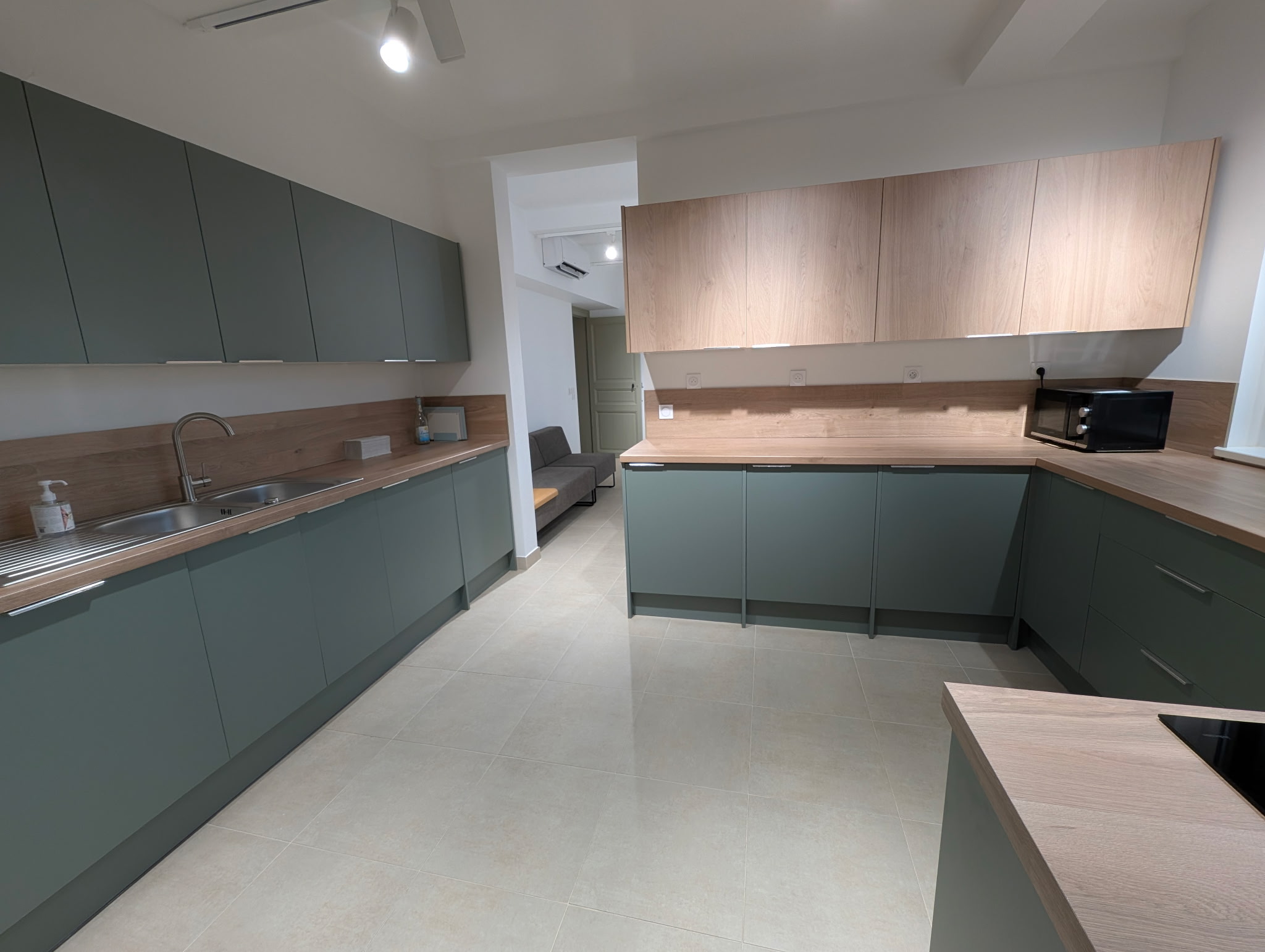 Une cuisine équipée de couleur vert olive et bois clair