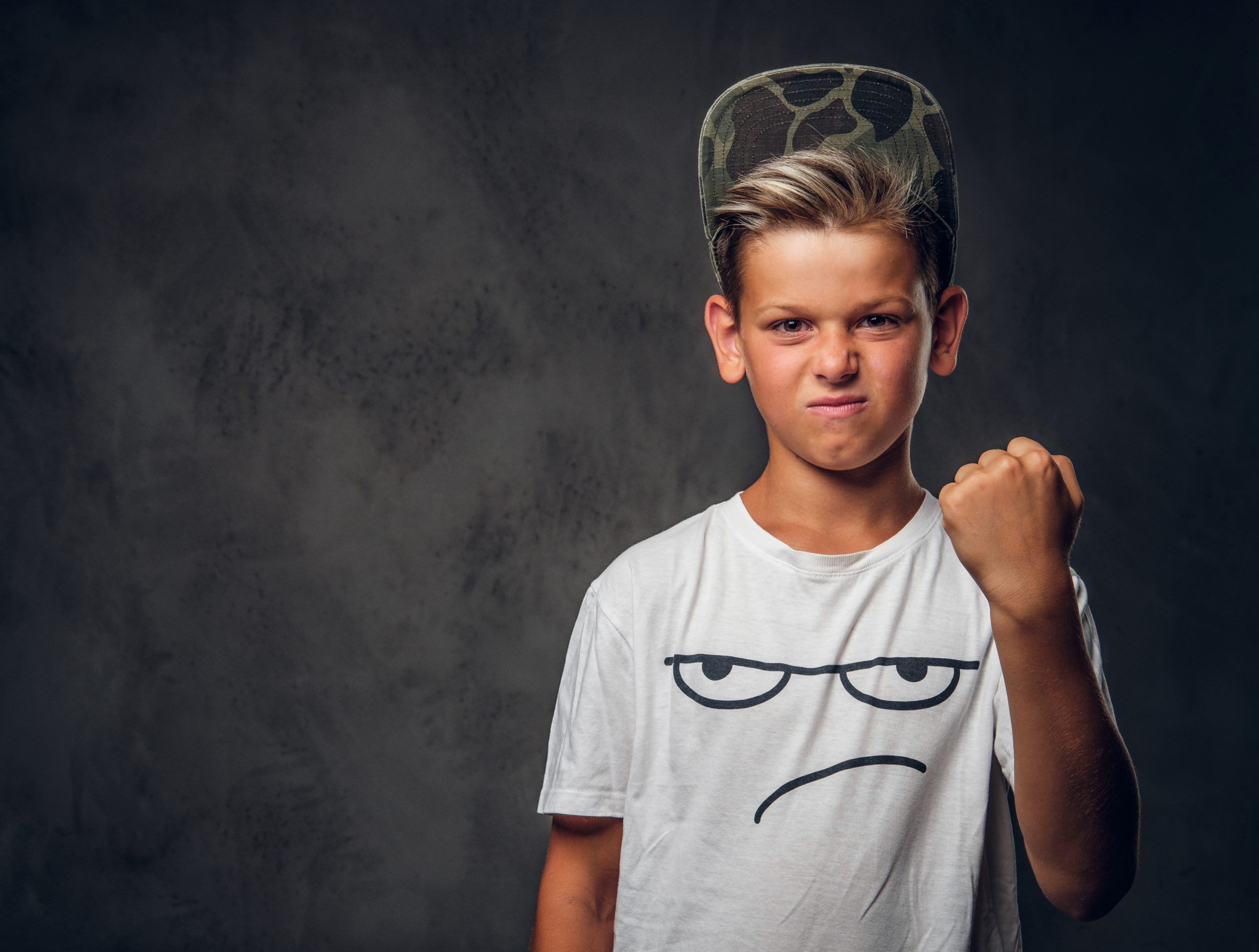 Un garçon d'environ 8 ans, en colère, qui serre le poing